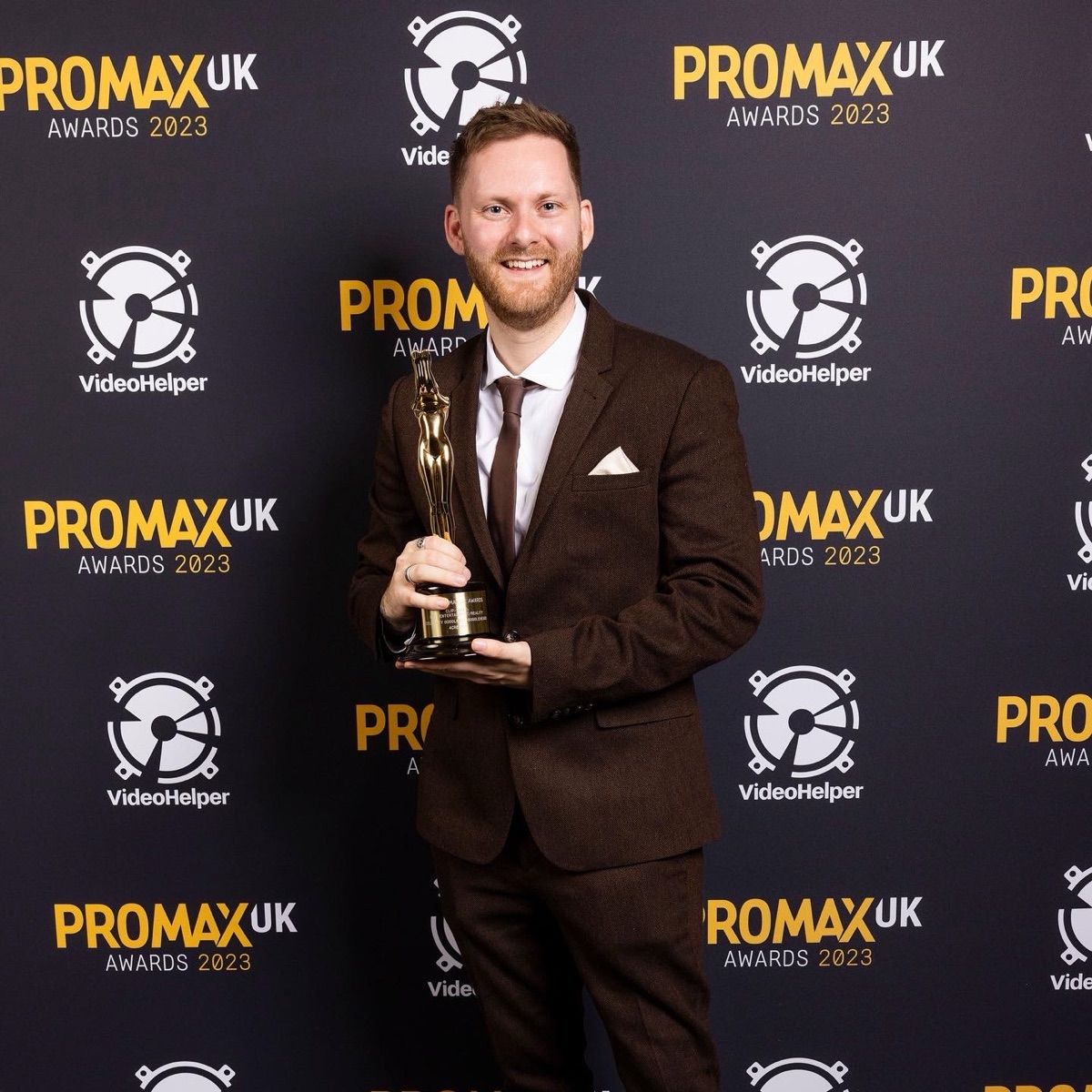 Lewis Clements holding a gold Promax UK award at the 2023 ceremony